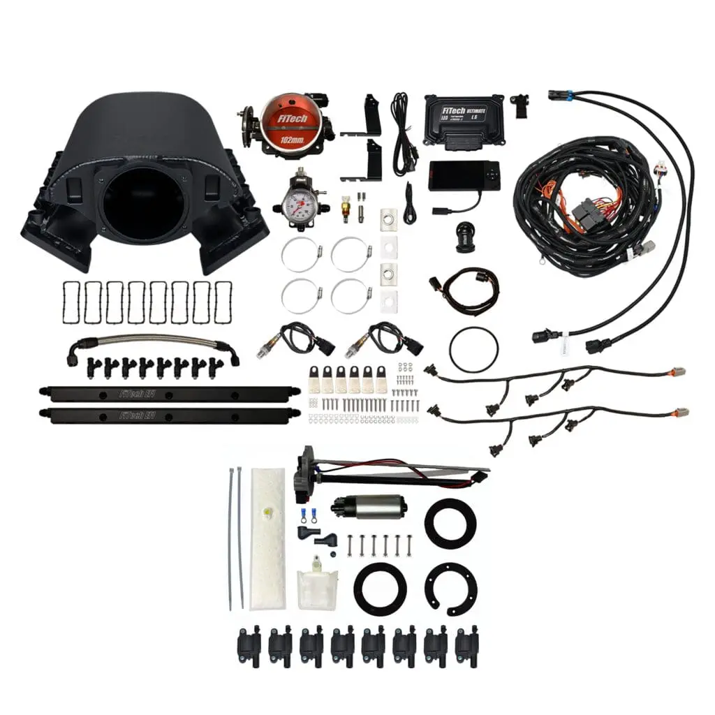 Automotive engine parts and accessories laid out.
