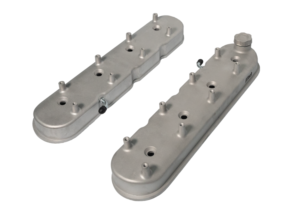 Silver engine valve covers on black background.