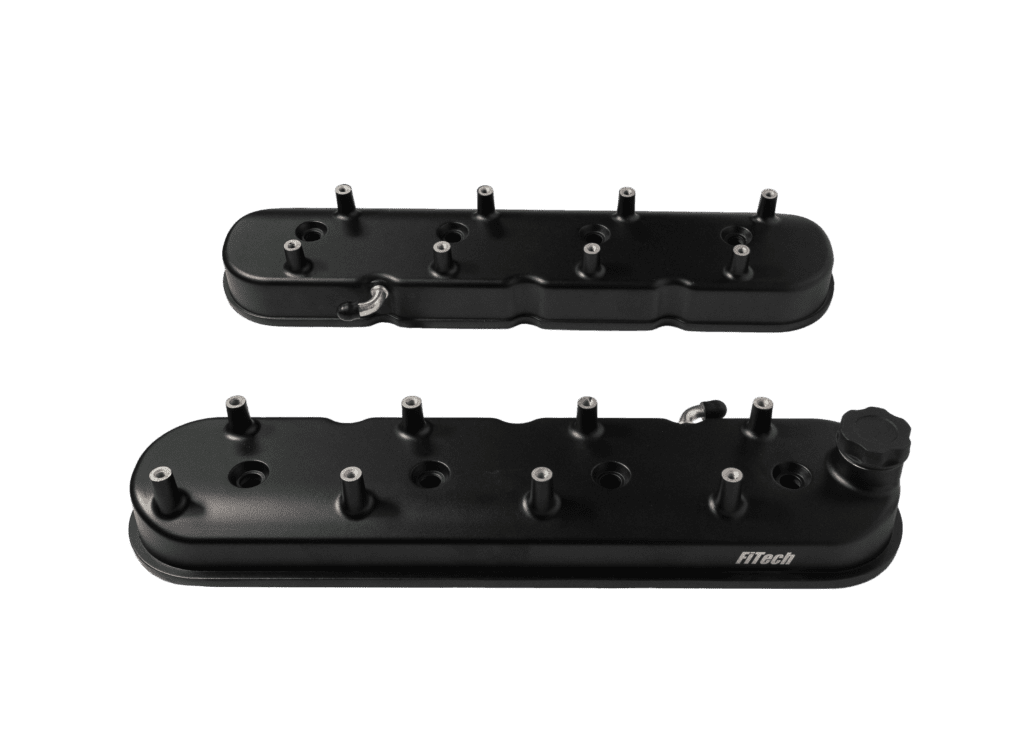 Black engine valve covers on black background.