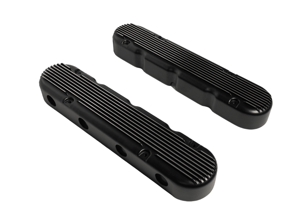 Black engine valve covers on black background.