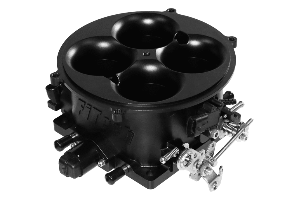 A black four-barrel carburetor for an engine.