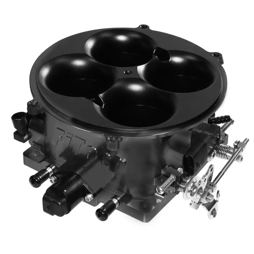 Black automotive carburetor with four barrels and linkage mechanisms.