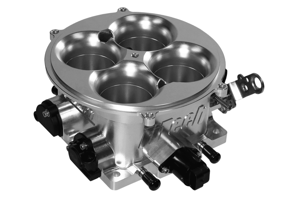 A silver automotive throttle body with four circular openings and attached sensors.