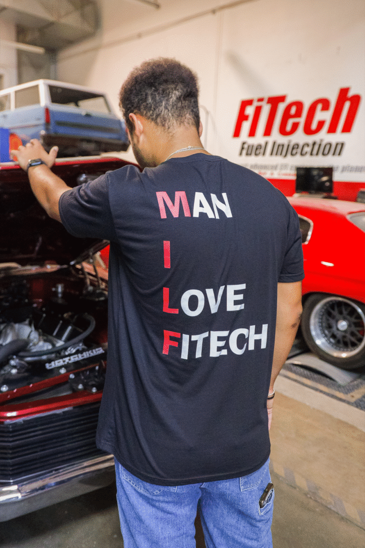 Person wearing a black FiTech shirt with a slogan about fuel injection.
