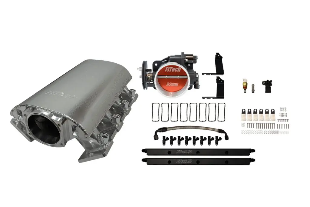 Car engine intake manifold with installation hardware laid out.