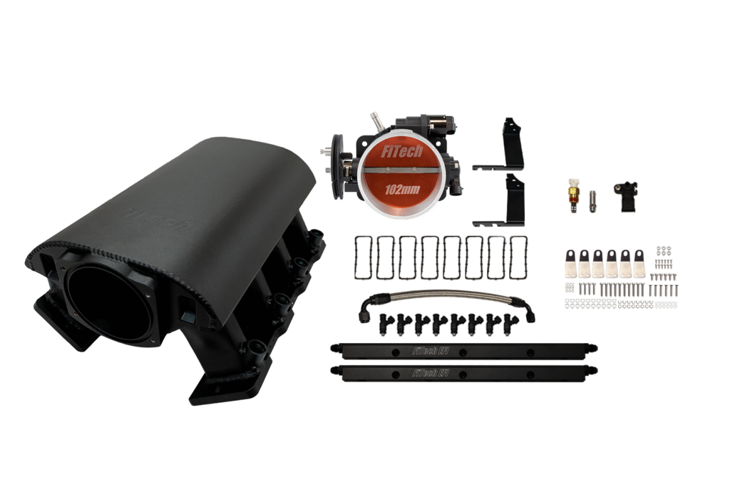 A black automotive intake manifold kit with various components laid out.