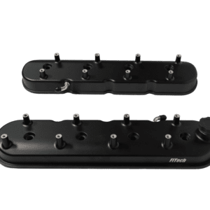 Black engine valve covers on black background.