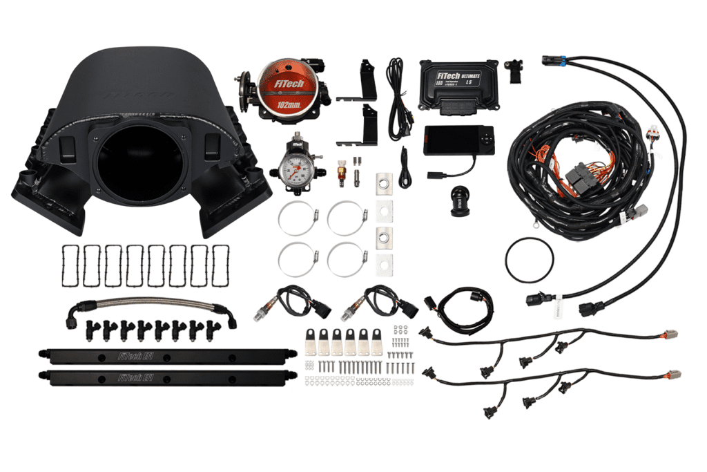Car engine components and wiring kit laid out.