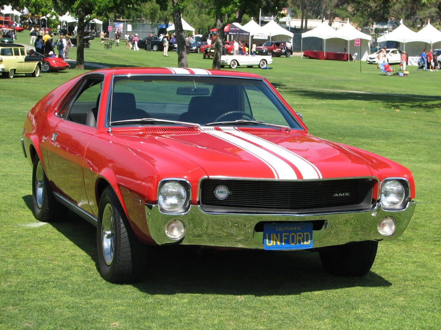 Red vintage car with white racing stripes.