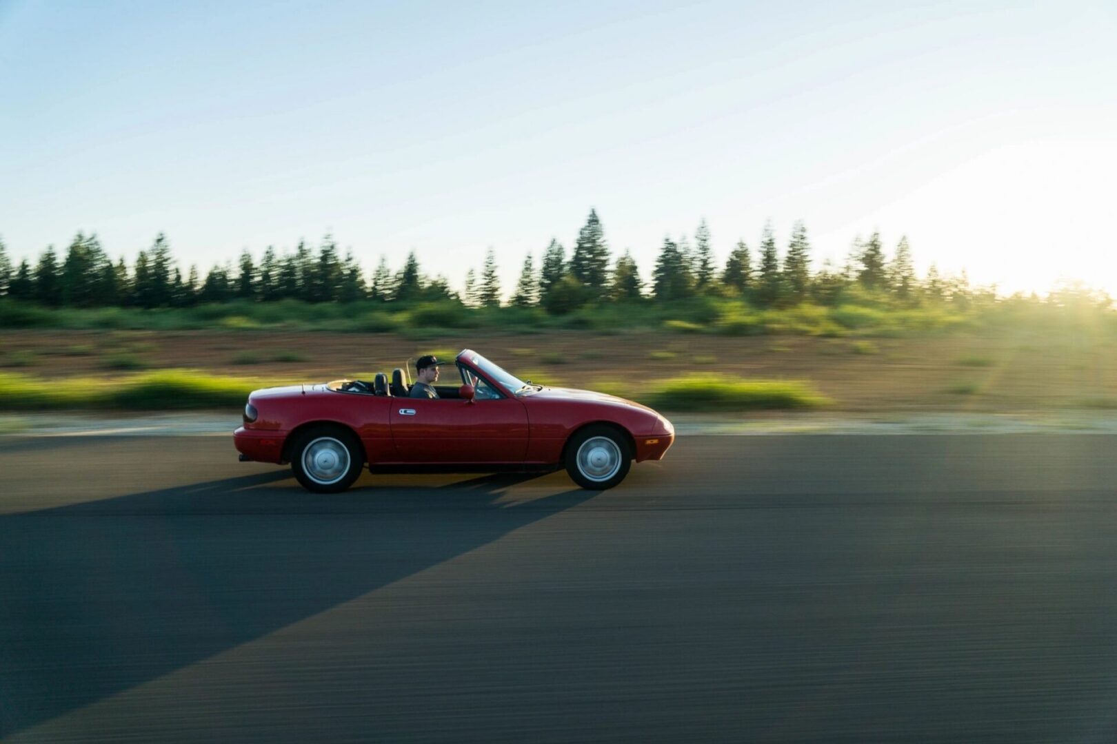 red car driving on a road