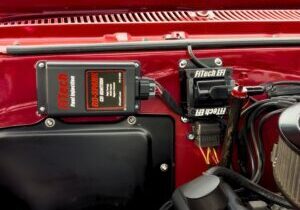 FiTech EFI ignition components mounted in a red Chevrolet engine bay